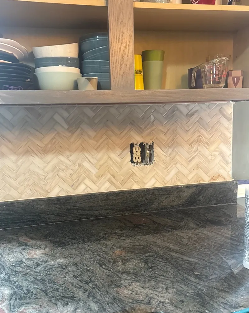 Herringbone: a mosaic herringbone backsplash under open shelves.