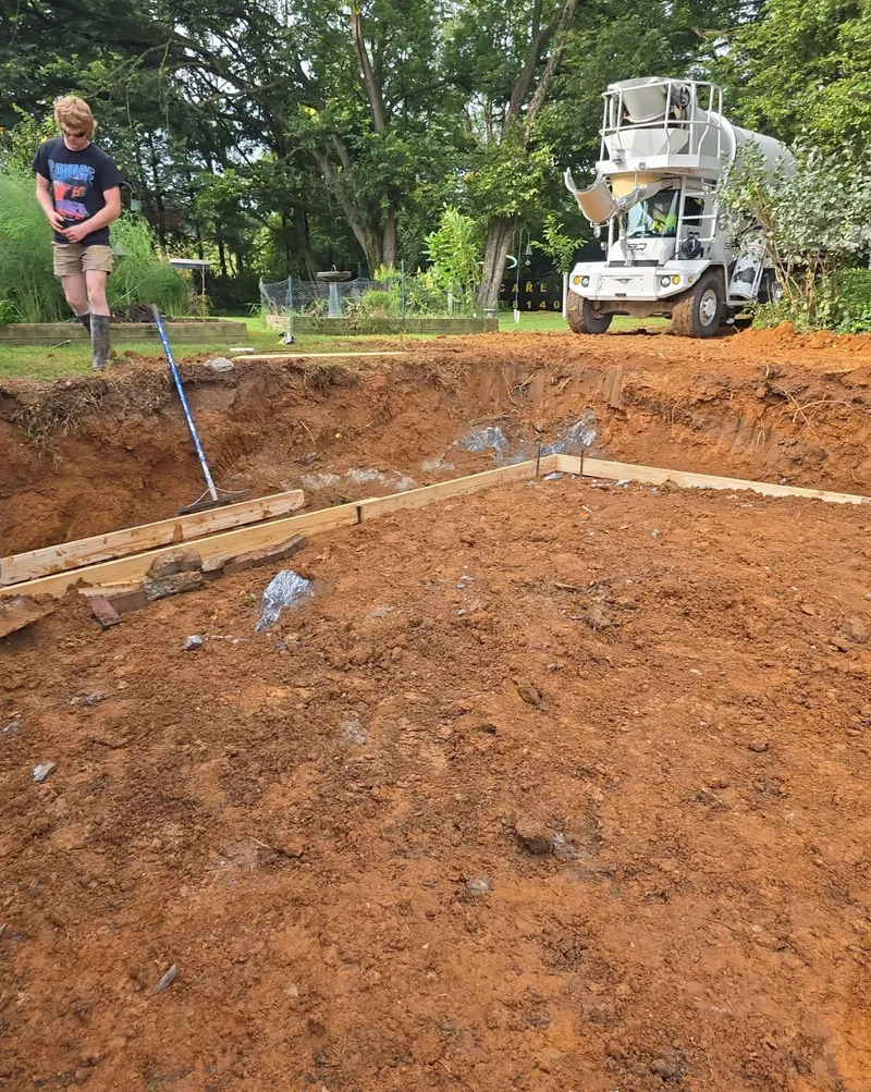 Concrete truck arriving at an excavated foundation site with the forms set out.